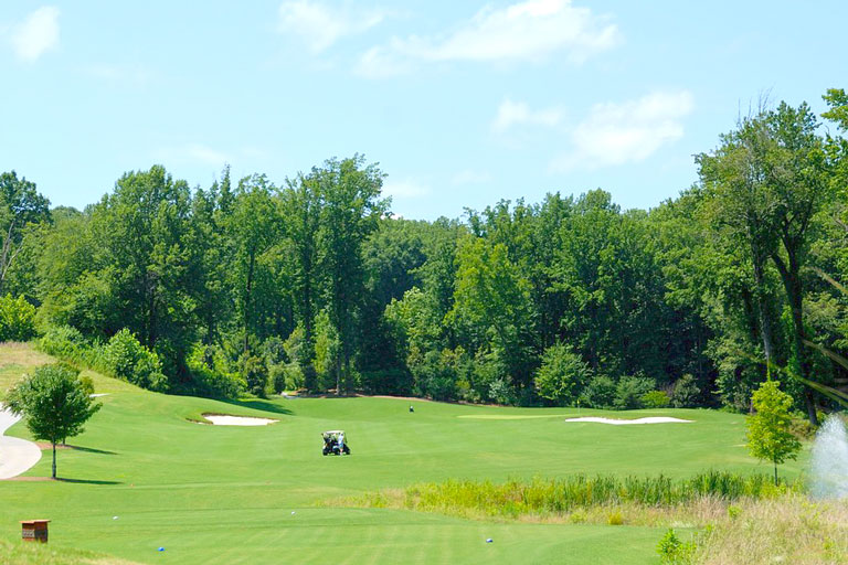 青い空と緑の芝が映えるゴルフ場の写真