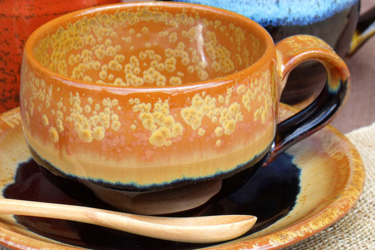 小砂焼の写真。黄金色の釉薬で塗られた陶器が美しいです。